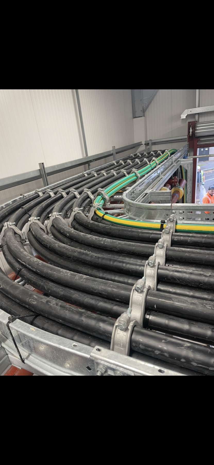 Power cables secured along a curved cable ladder