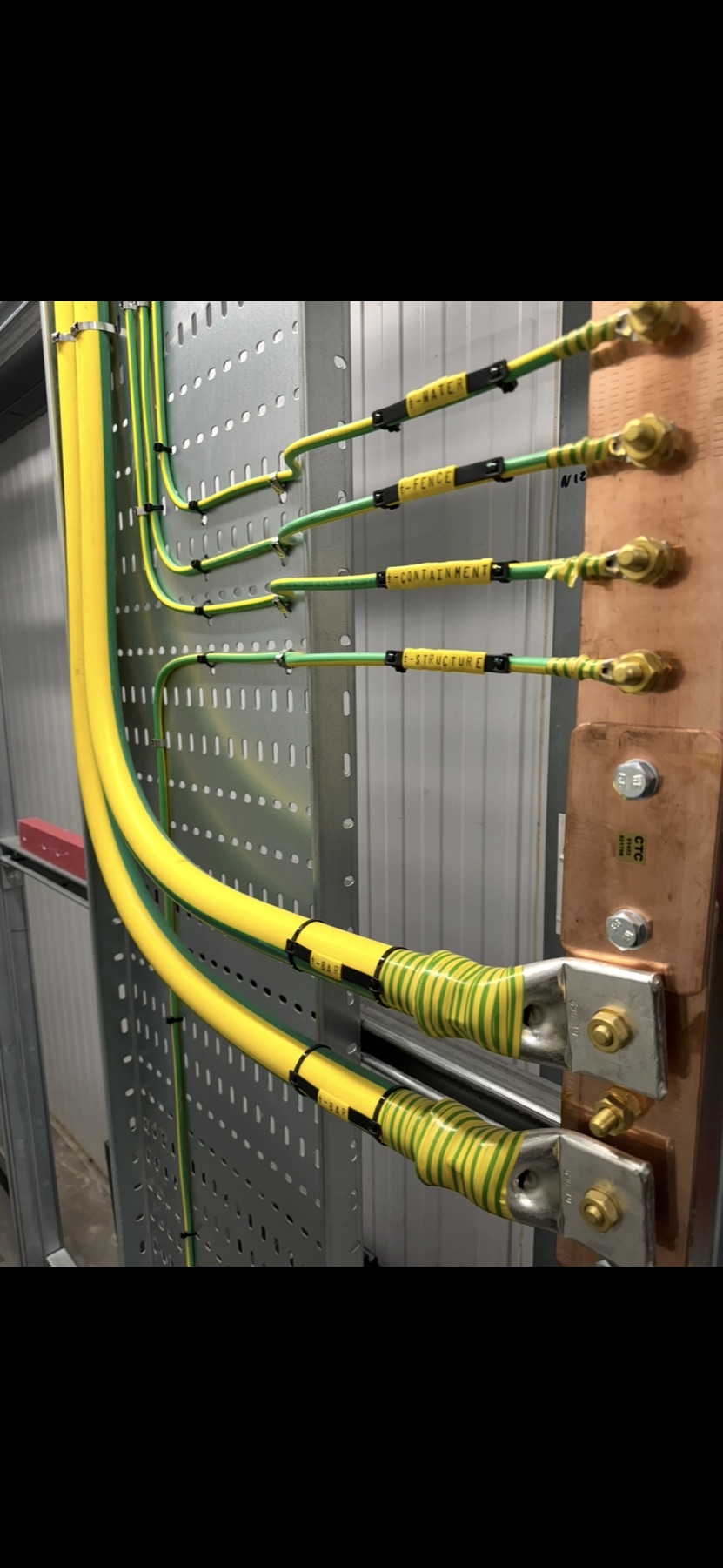 Labelled green and yellow conductors connected to a copper earth bar